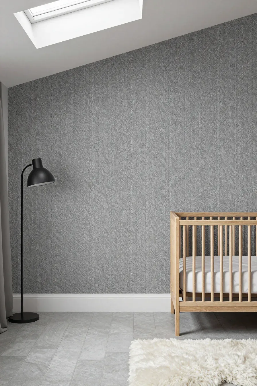 Subtle grey herringbone wallpaper in a minimalist nursery with mid-century modern furniture.