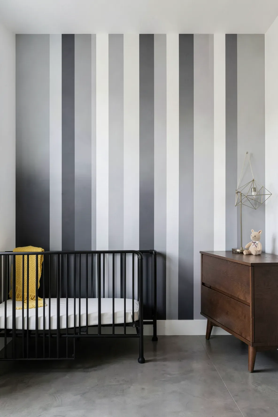 Modern nursery with vertical gray ombre stripes fading from dark at the bottom to light at the top.