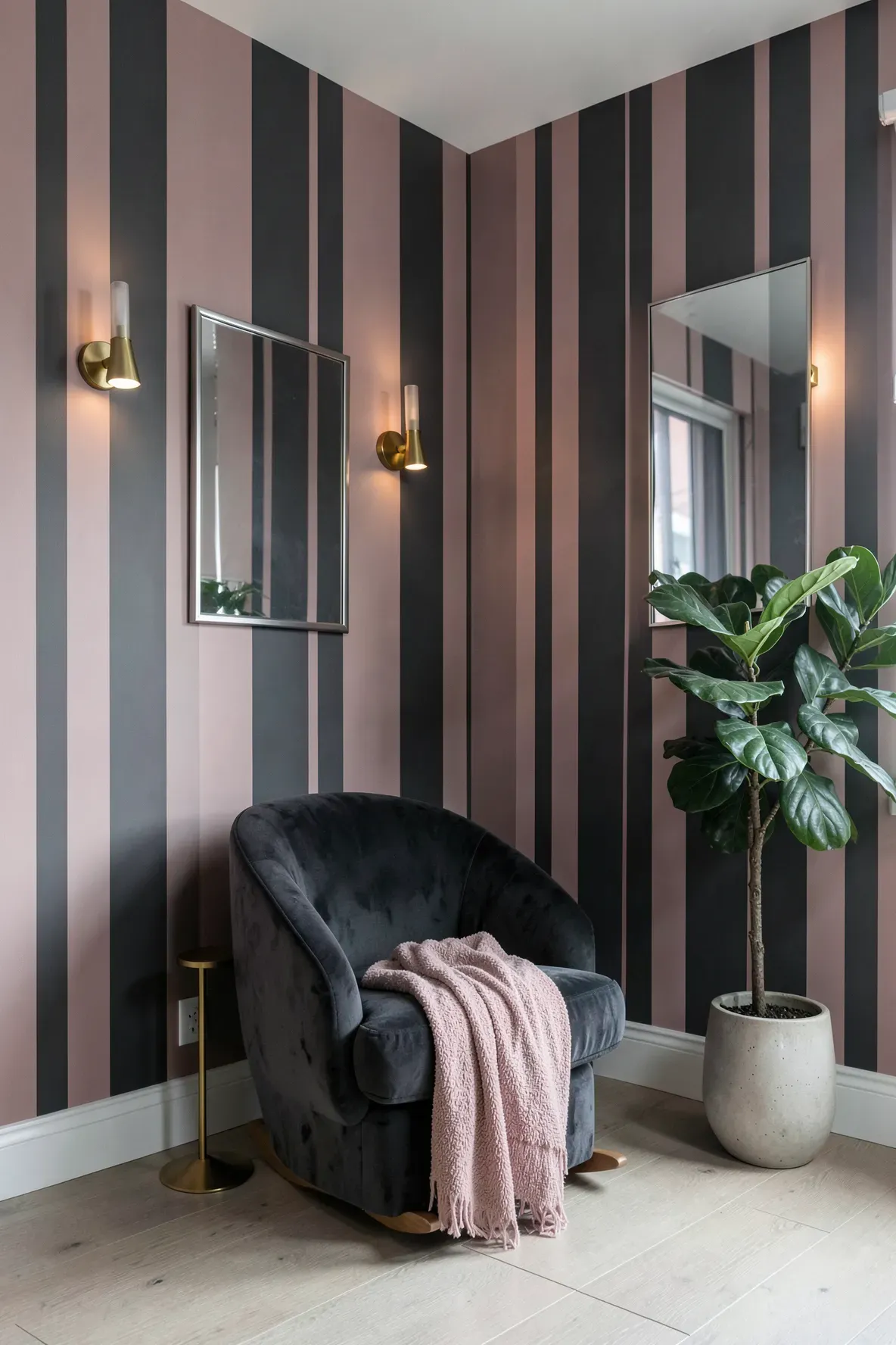 Modern nursery with bold dusty rose and charcoal gray striped wallpaper and gold accents.