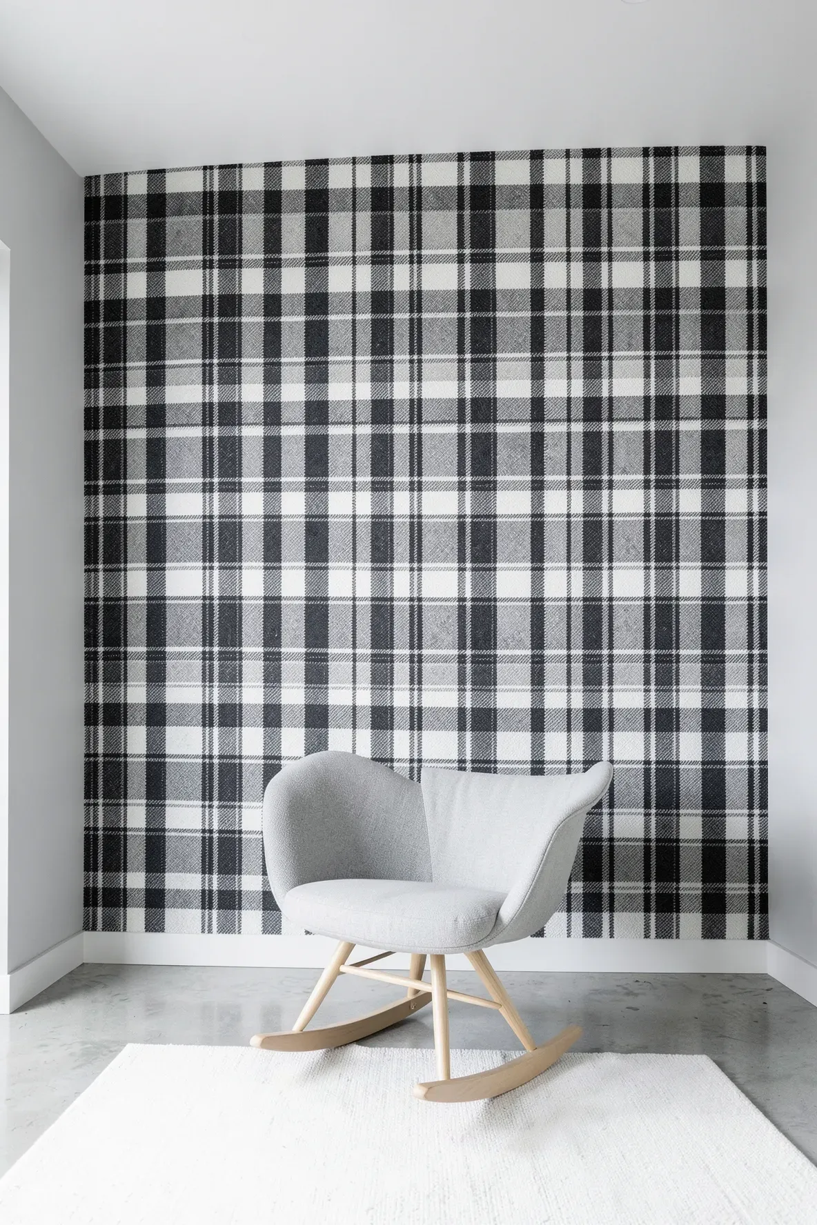 A modern nursery with a bold charcoal and white large-scale buffalo plaid accent wall.