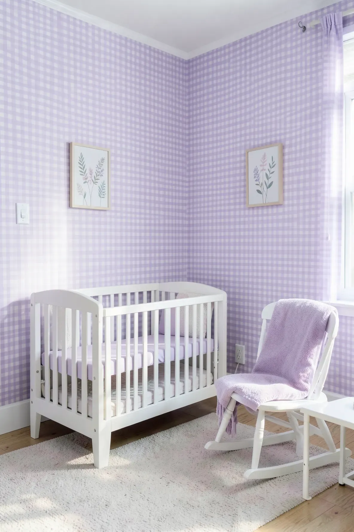 A peaceful nursery with lavender gingham wallpaper and bright white painted furniture.
