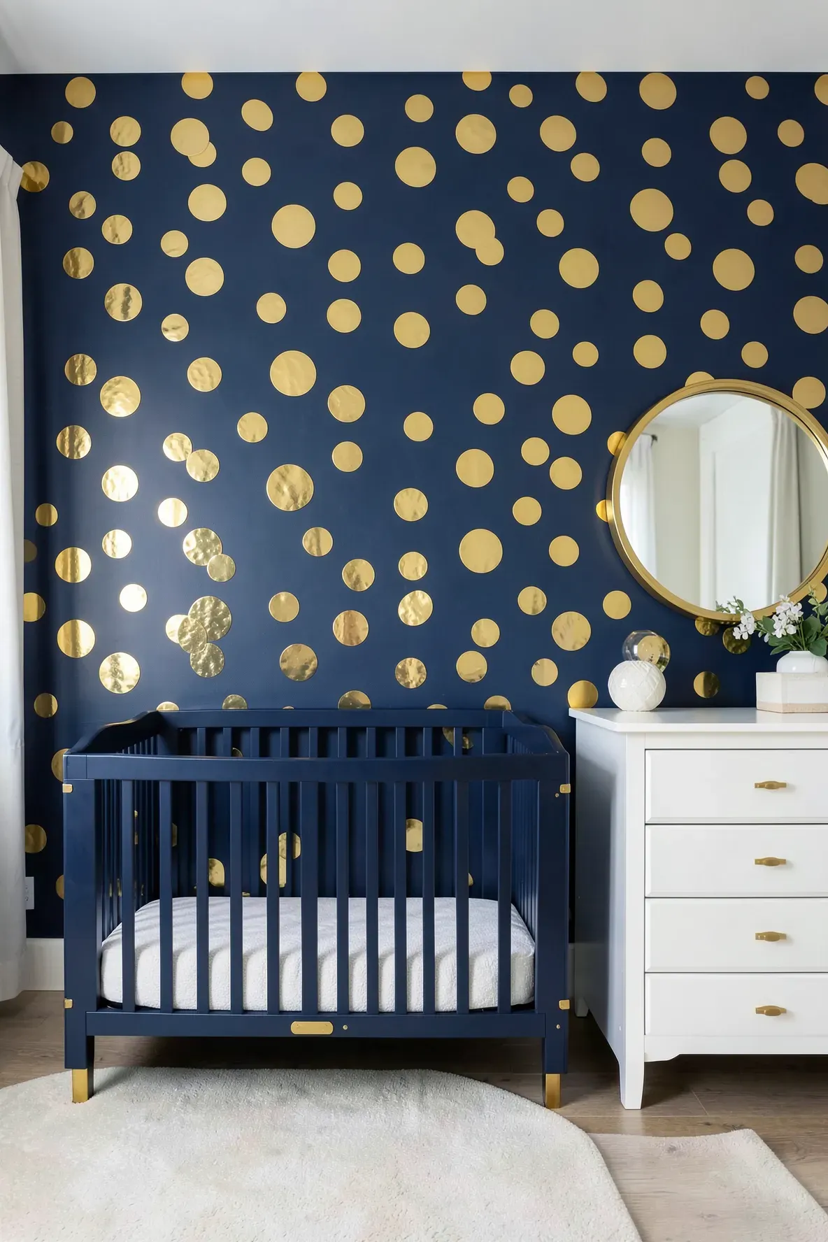 A luxury nursery featuring an accent wall with large gold metallic dots on navy blue.