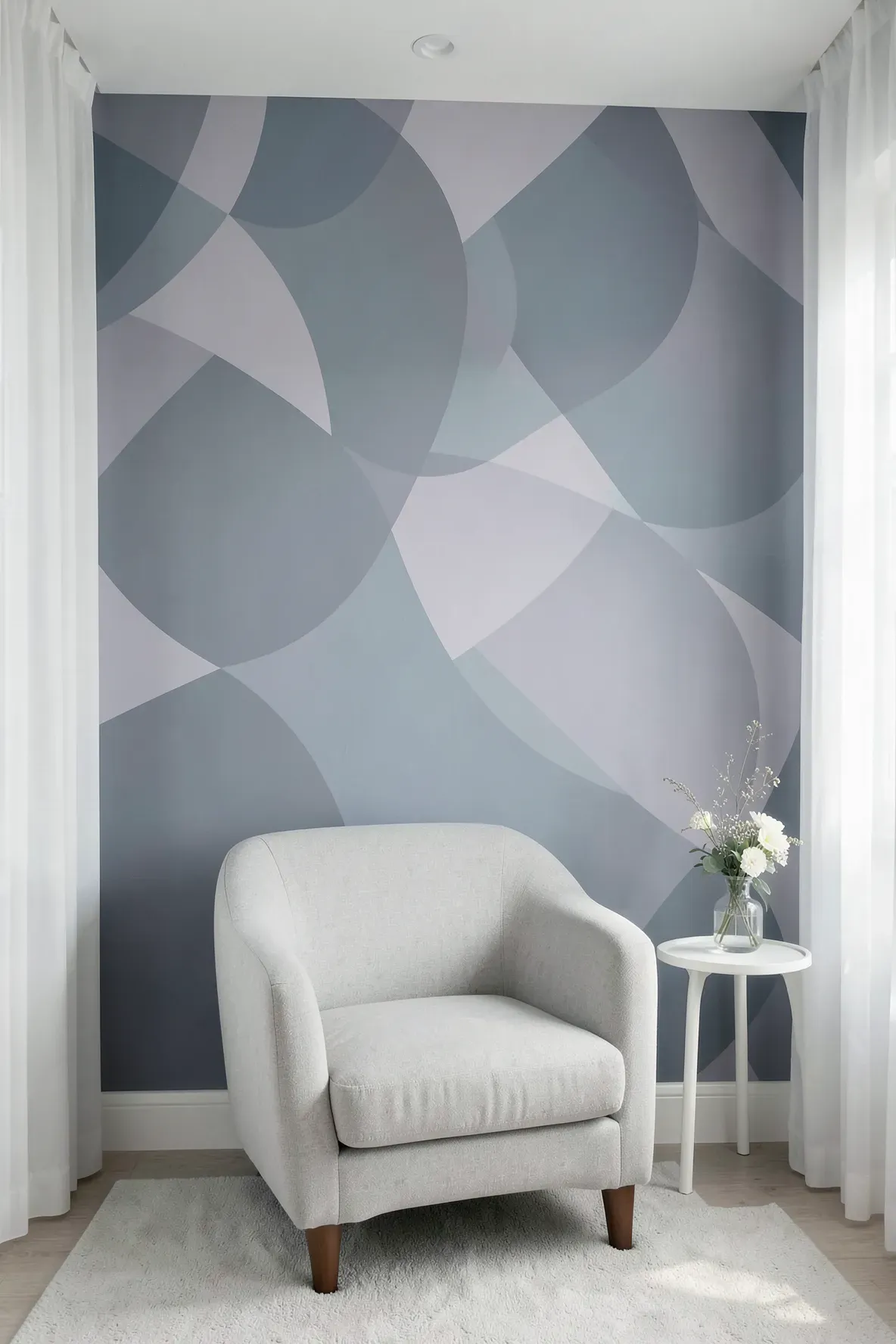 Soothing nursery wall with overlapping blue and grey ovals behind a grey glider chair.