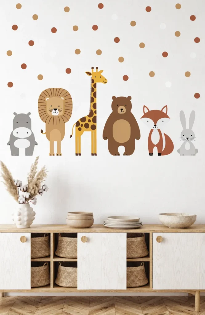 Minimalist nursery wall with a lineup of earth-toned animal decals like a hippo, lion, and bear above a wood cabinet.