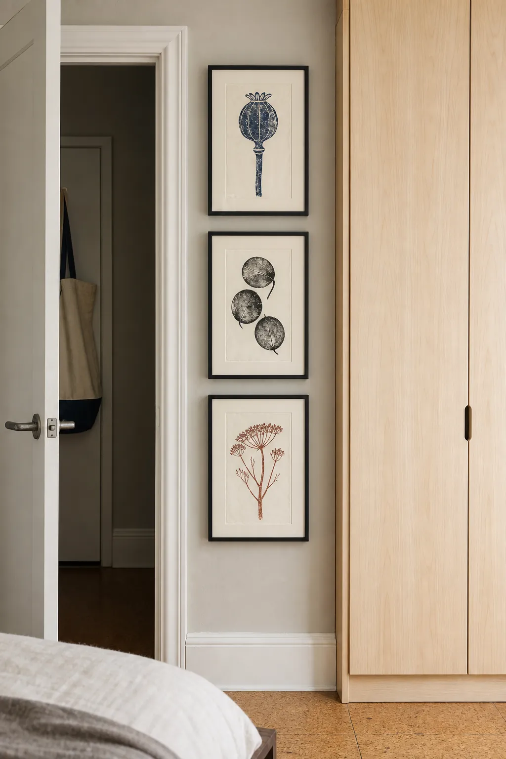 Three vertically stacked block prints emphasizing height in a small bedroom