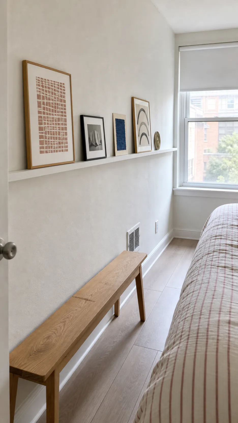Long slim picture ledge visually widening a narrow minimalist bedroom