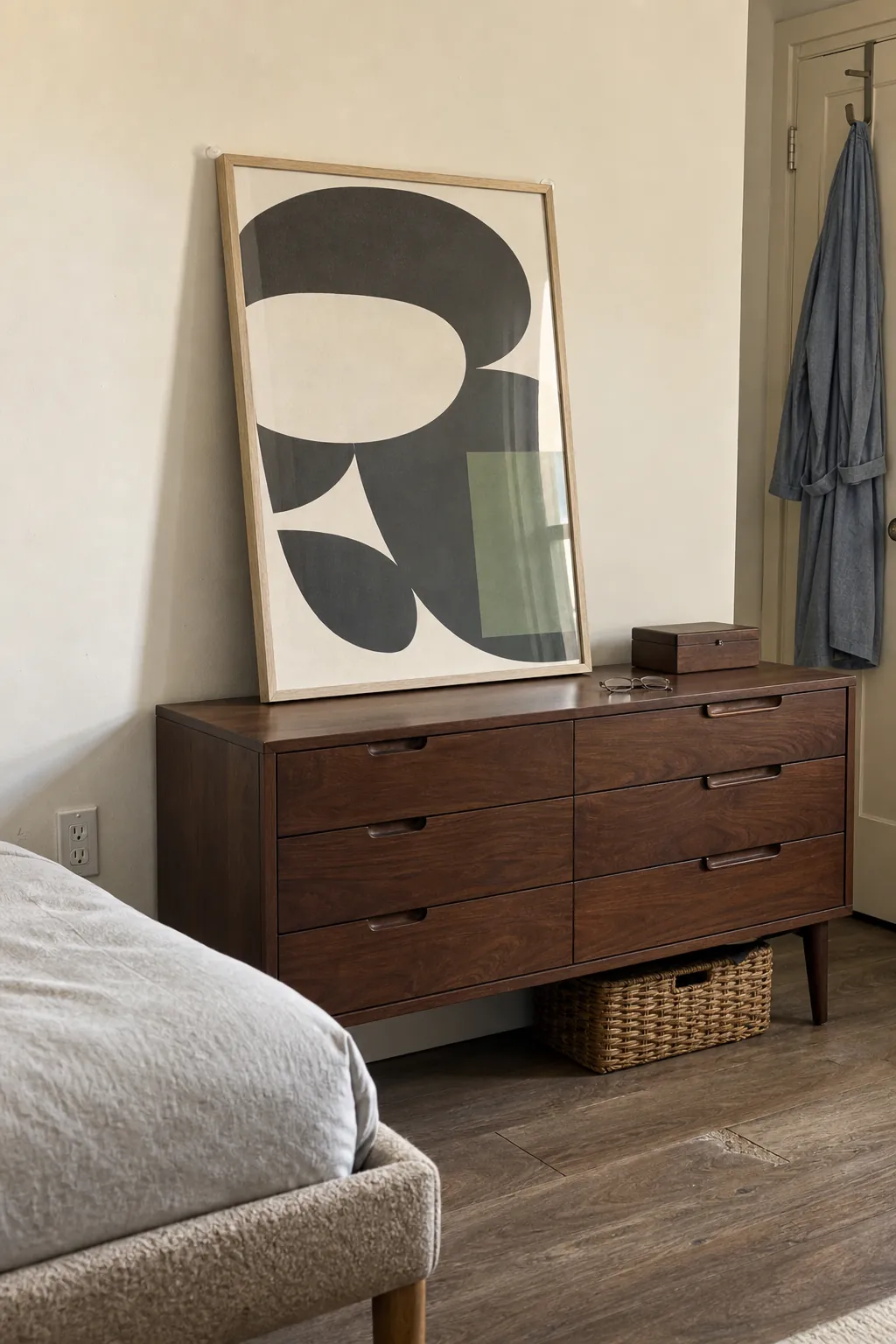 Large lightweight framed print leaning safely on a rental bedroom dresser