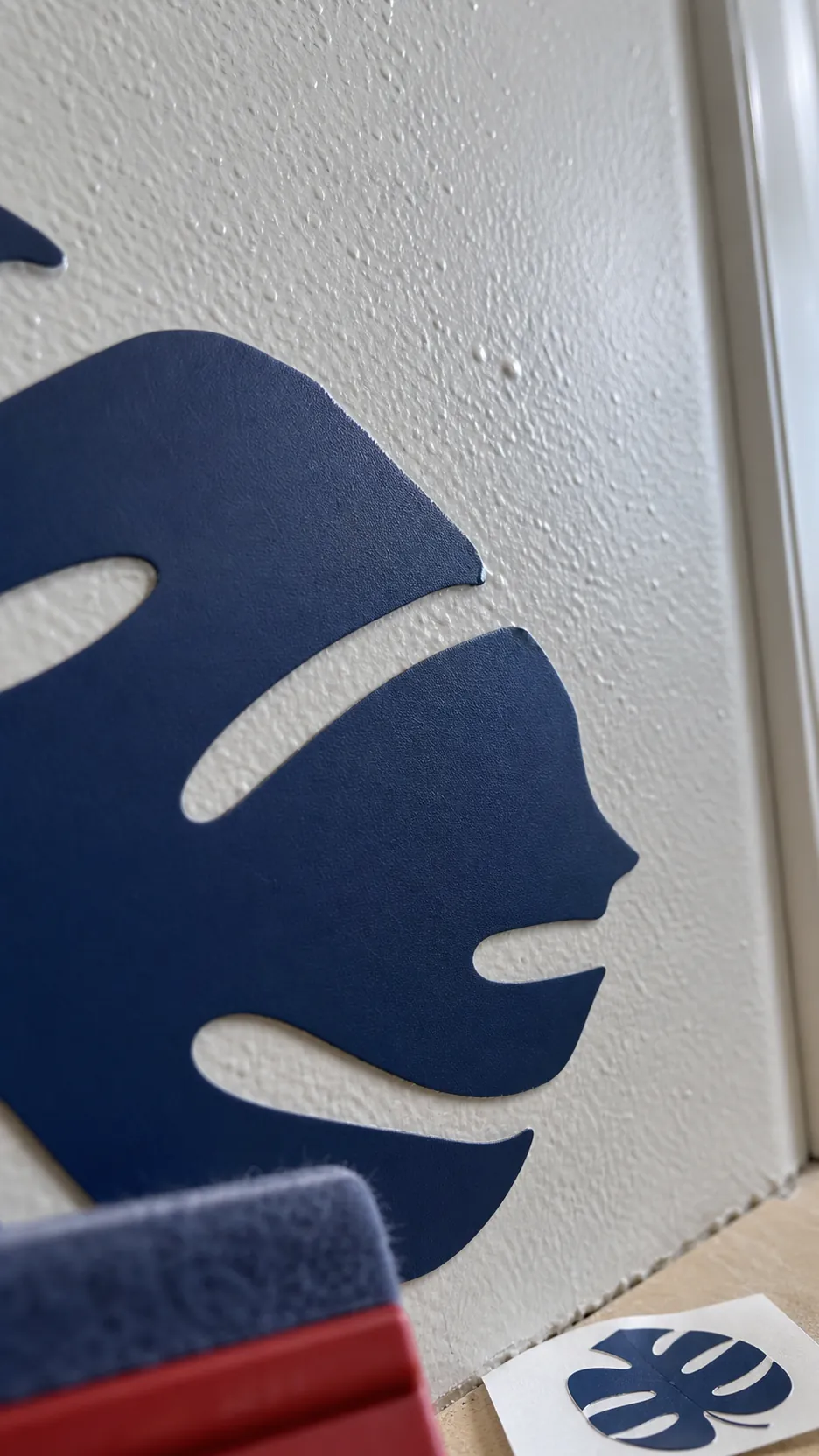 Close view of a vinyl wall decal pressed onto a lightly textured painted wall