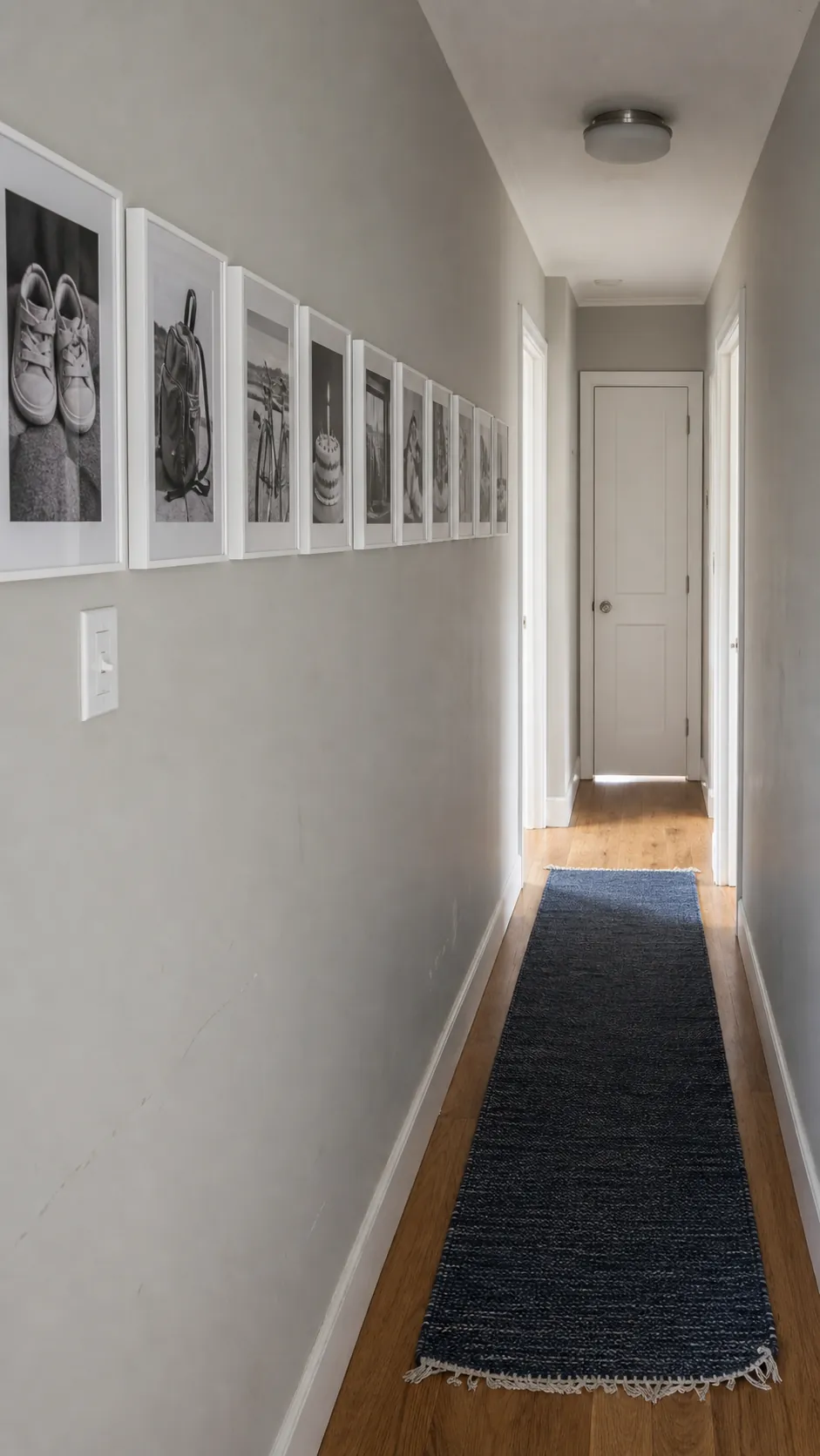 Lightweight framed photo timeline along a narrow rental hallway