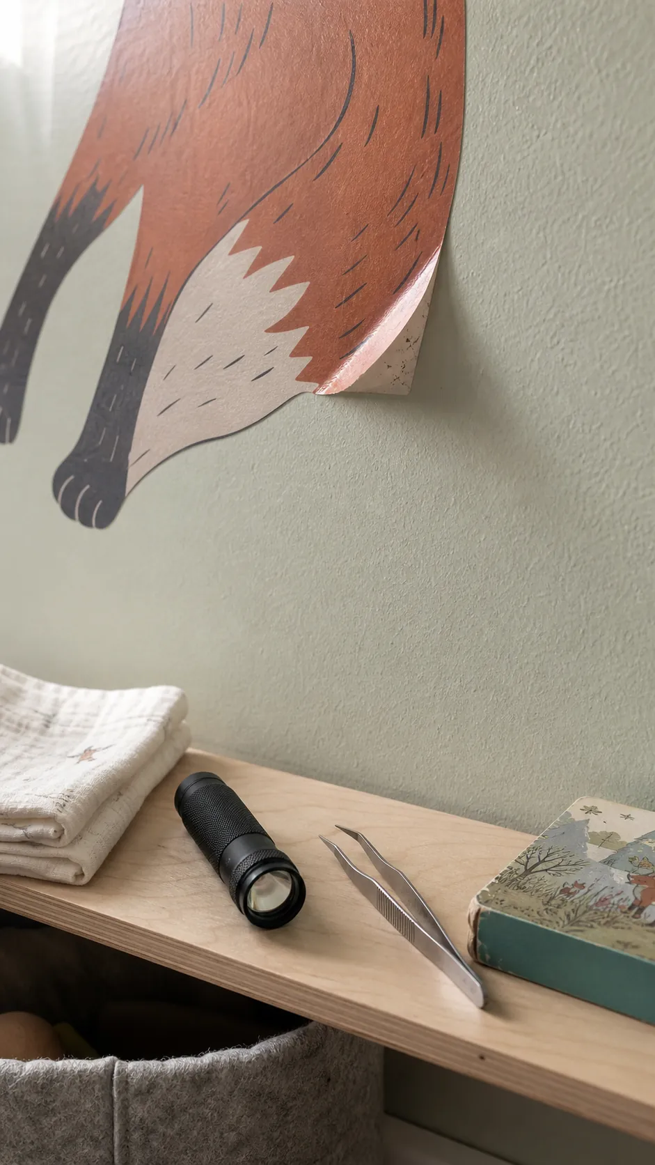 Close view of a wall decal corner lifting from a painted wall