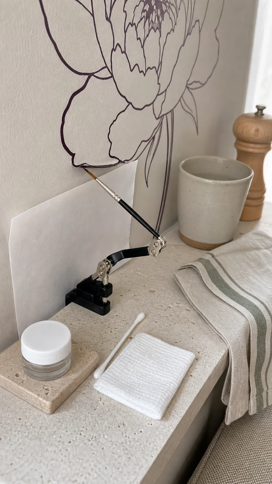 Fine brush applying a tiny amount of clear adhesive beneath a wall decal edge