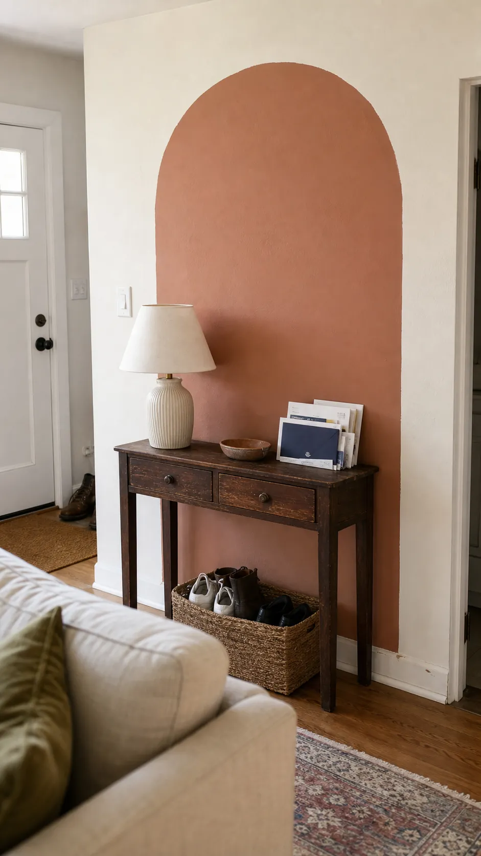 Muted clay painted arch framing a slim living room console