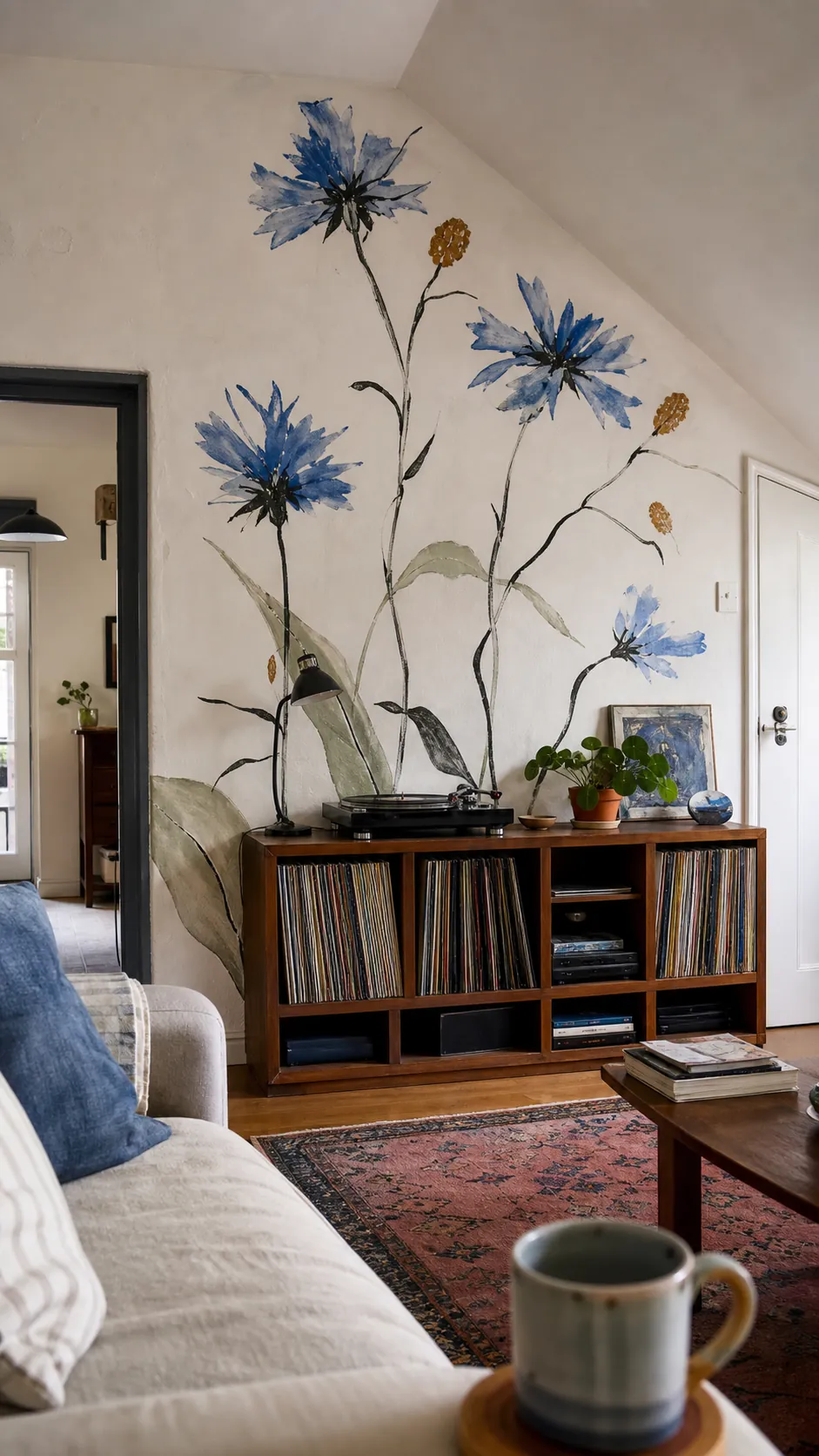 Loose hand-painted ochre and blue floral mural behind a low cabinet