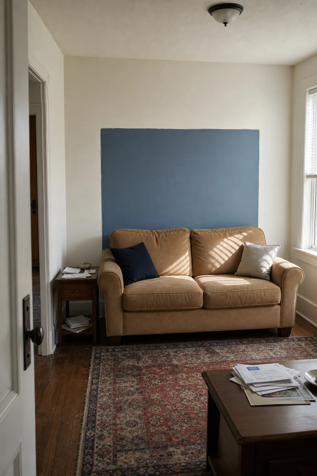 Smoky blue painted color field behind a compact sofa