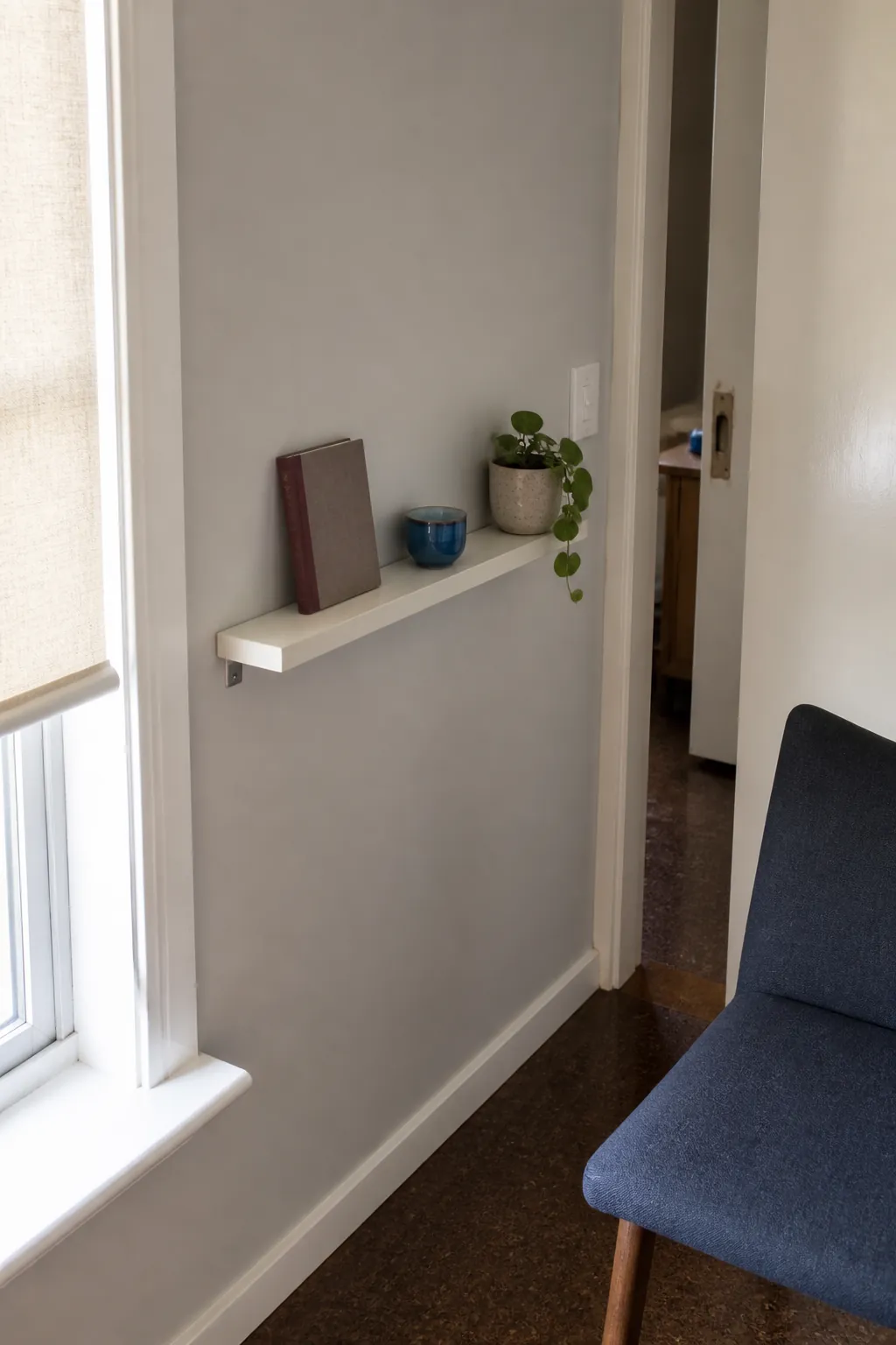 Shallow book ledge providing a small empty wall solution in a narrow room