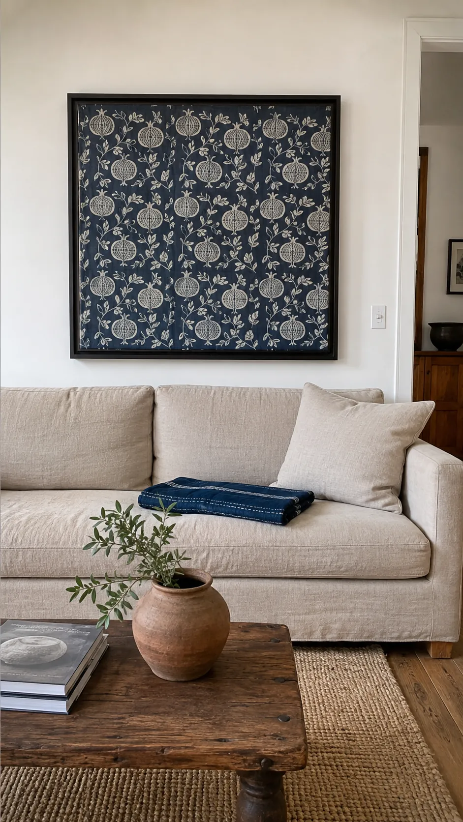 Framed block print fabric remnant above a simple sofa