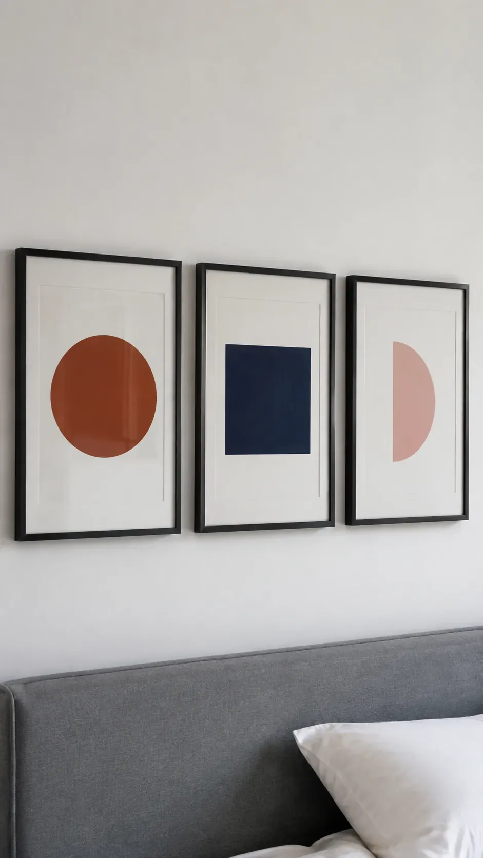 Even spacing between three graphic prints above a bed