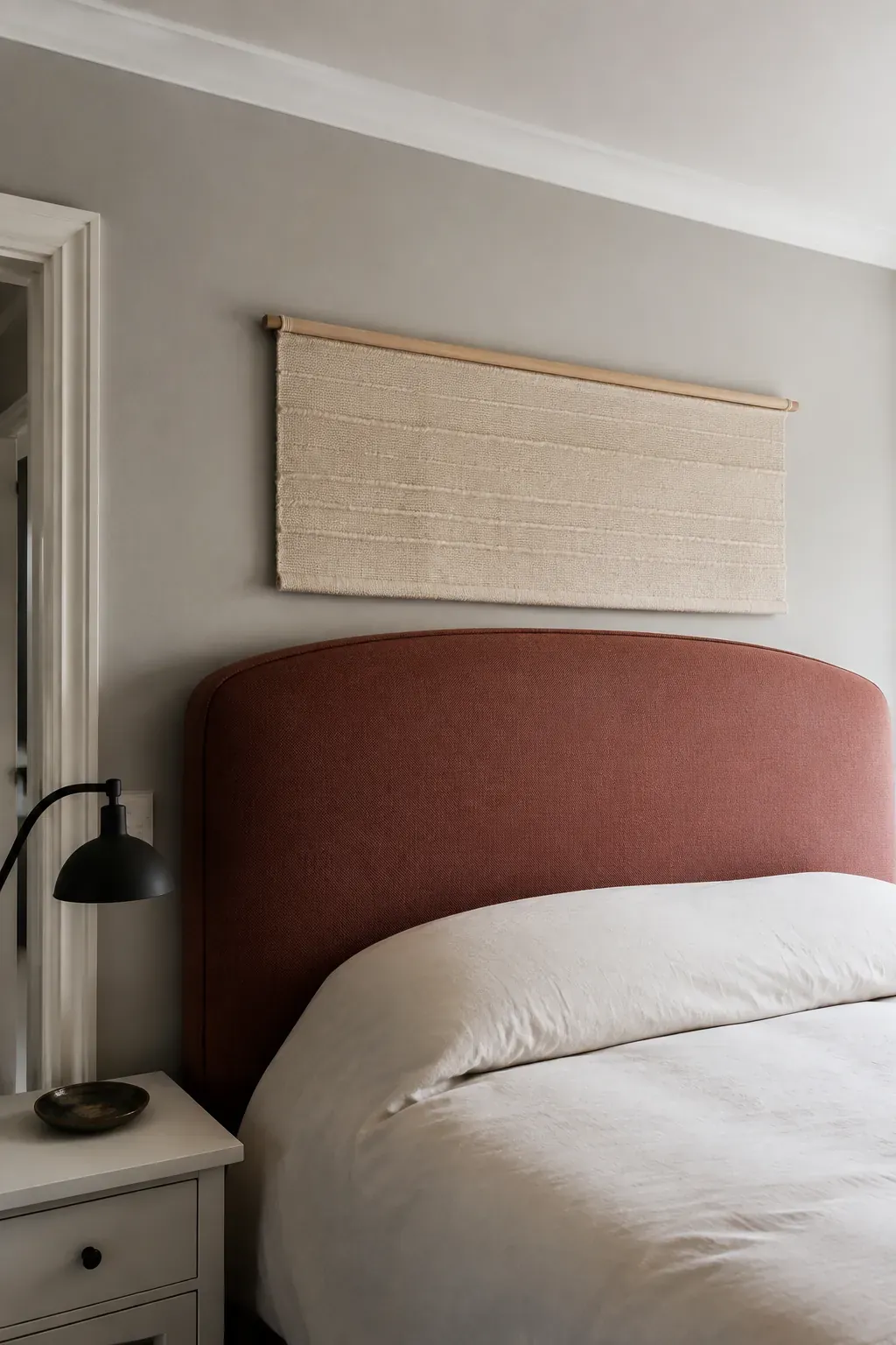 Shallow woven textile above a tall sculpted king headboard