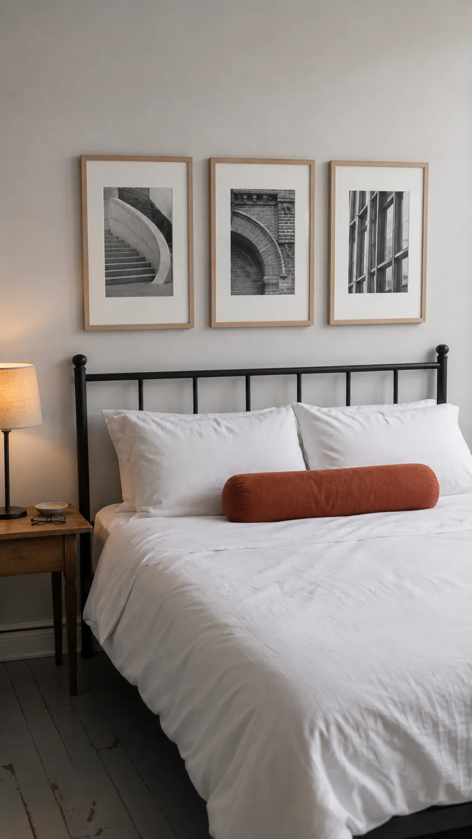 Three small architectural photographs grouped above a queen bed