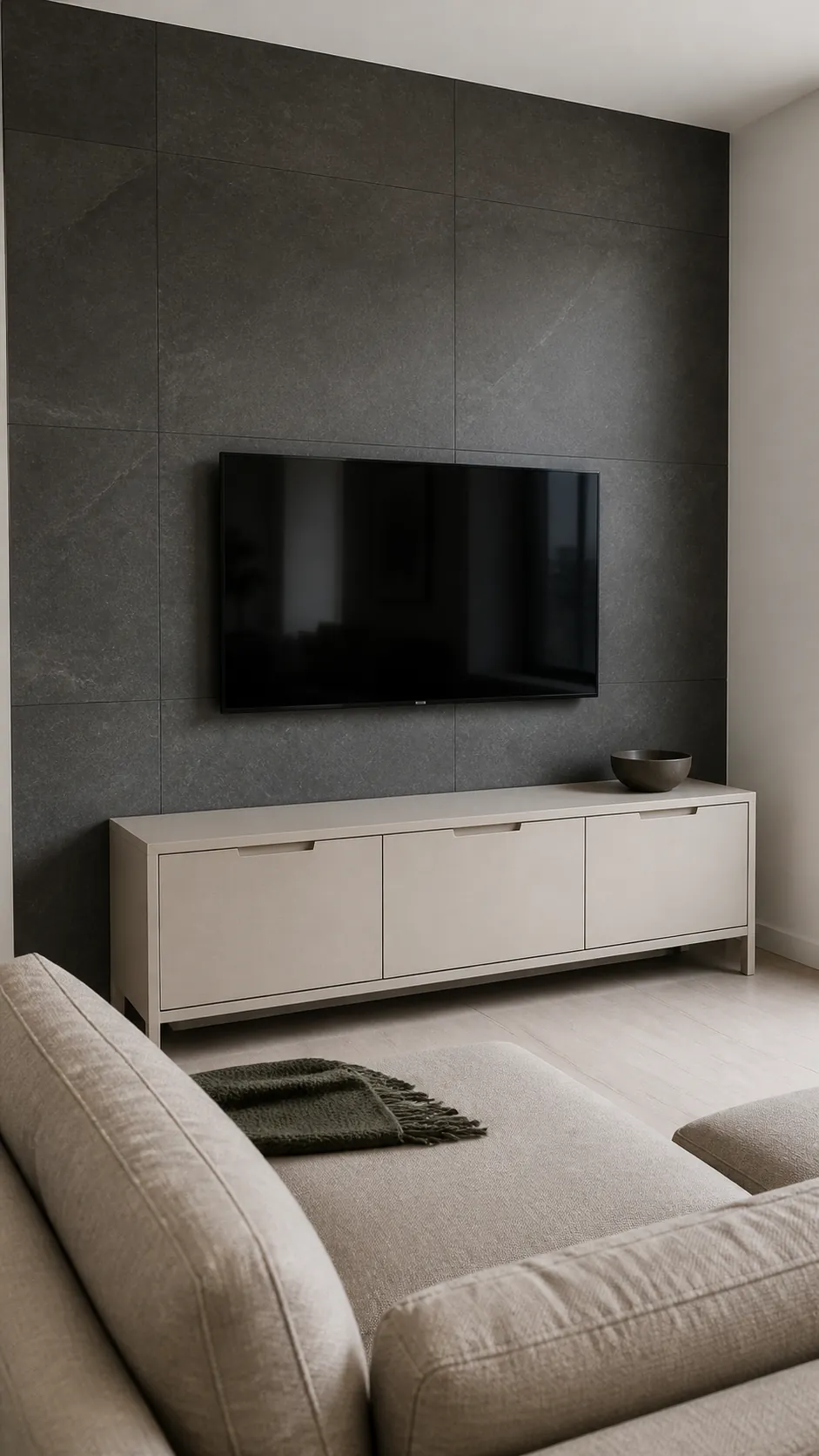 Large matte slate look tiles behind a television in a lived in room