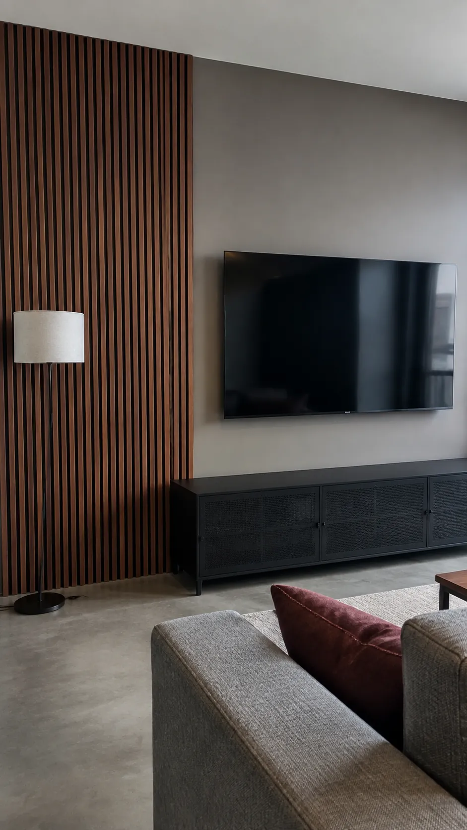 Walnut slats beside a quiet screen zone behind a television in a lived in room
