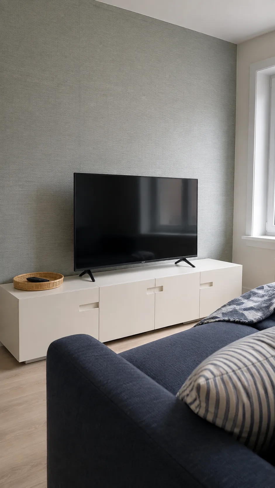 A subtle grasscloth effect covering behind a television in a lived in room
