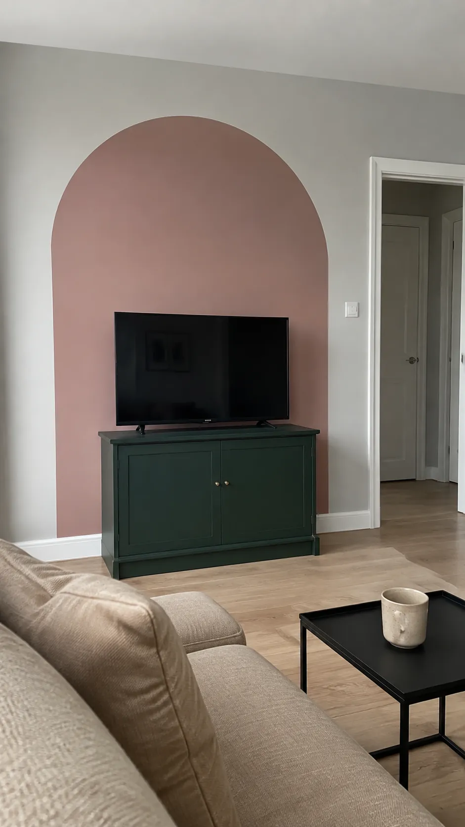 A softly painted arch behind a television in a lived in room