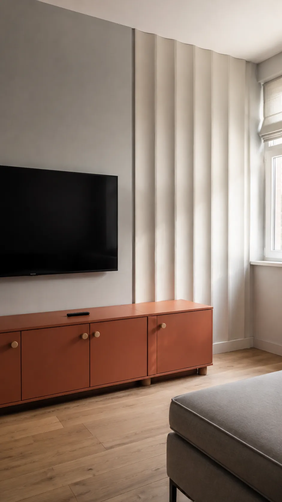 Broad sculpted gypsum ribs behind a television in a lived in room