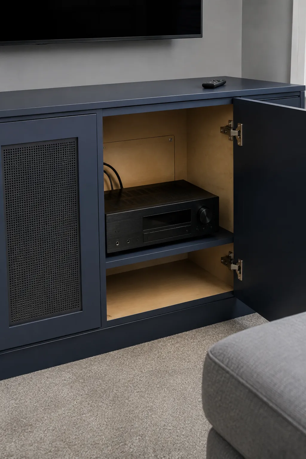 A ventilated equipment cupboard in a practical built in television wall