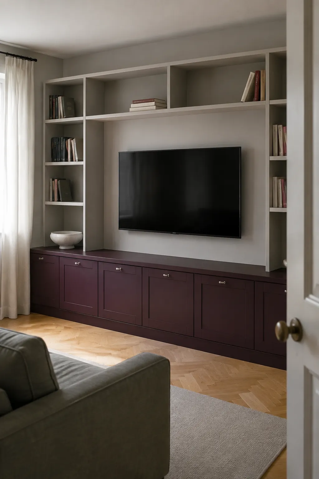 Pale upper shelves and a darker base in a practical built in television wall