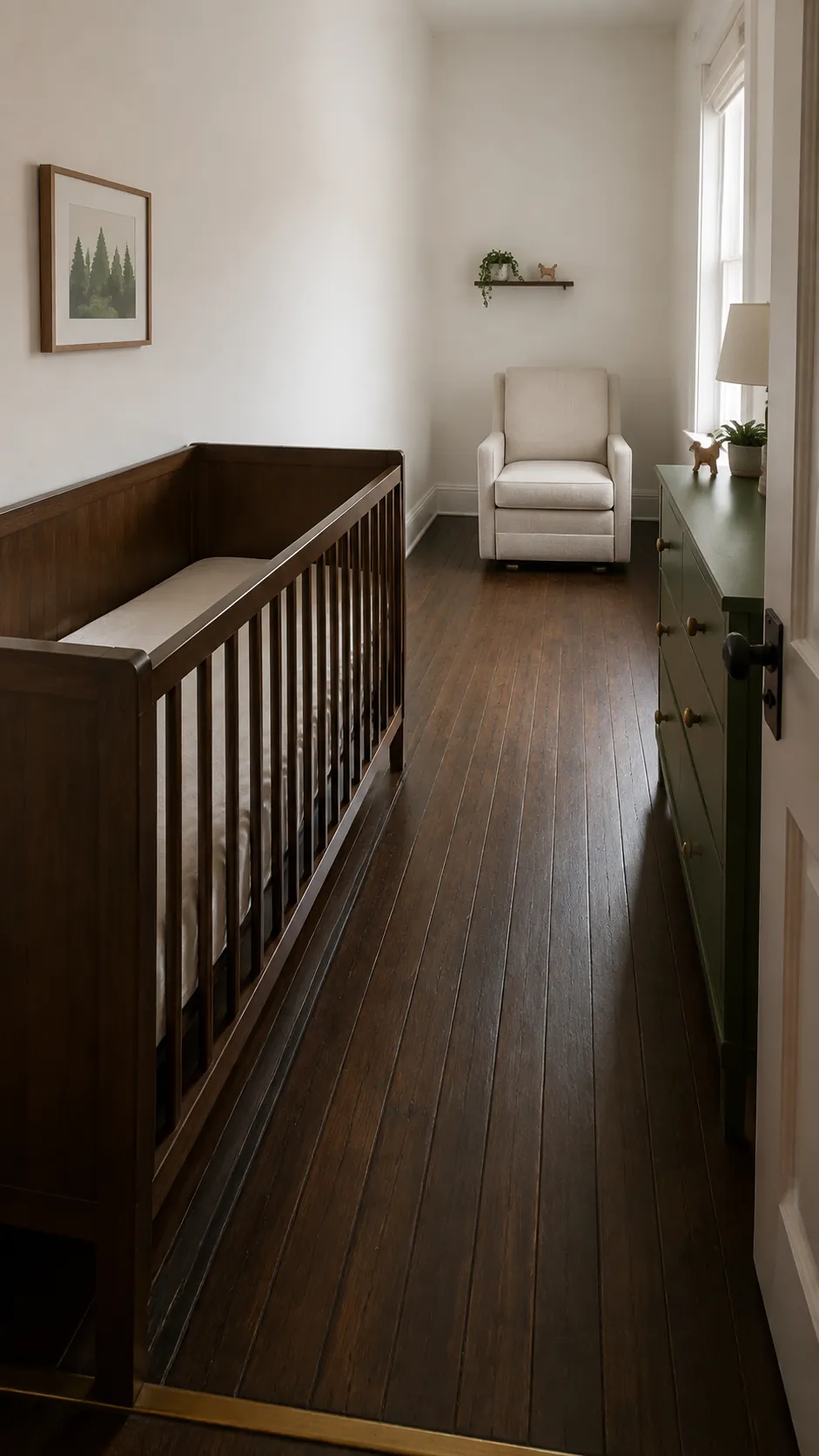 Make a narrow nursery feel understandable by showing the crib lengthwise along its longest uninterrupted wall and the surviving passage beside it