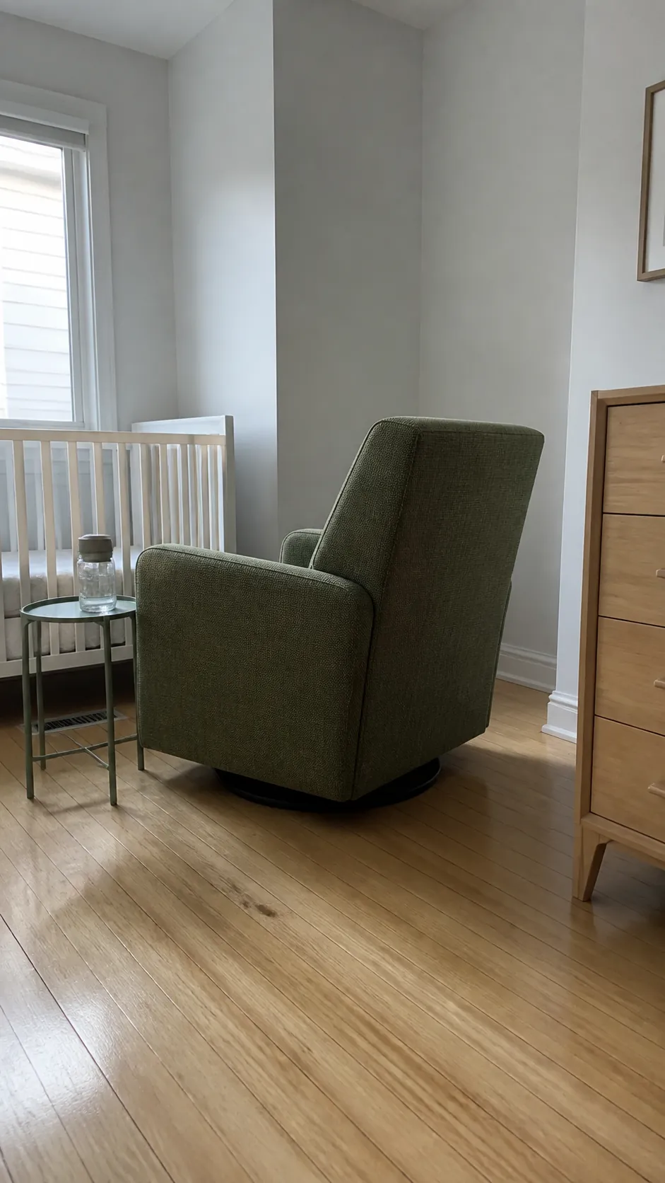 Explain how a slightly angled glider can turn an awkward nursery corner into a workable sitting area while preserving the crib approach