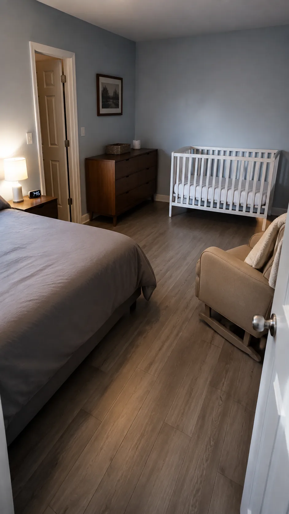 Show a nursery corner integrated into a small shared adult bedroom while keeping the infant sleep surface separate and clear