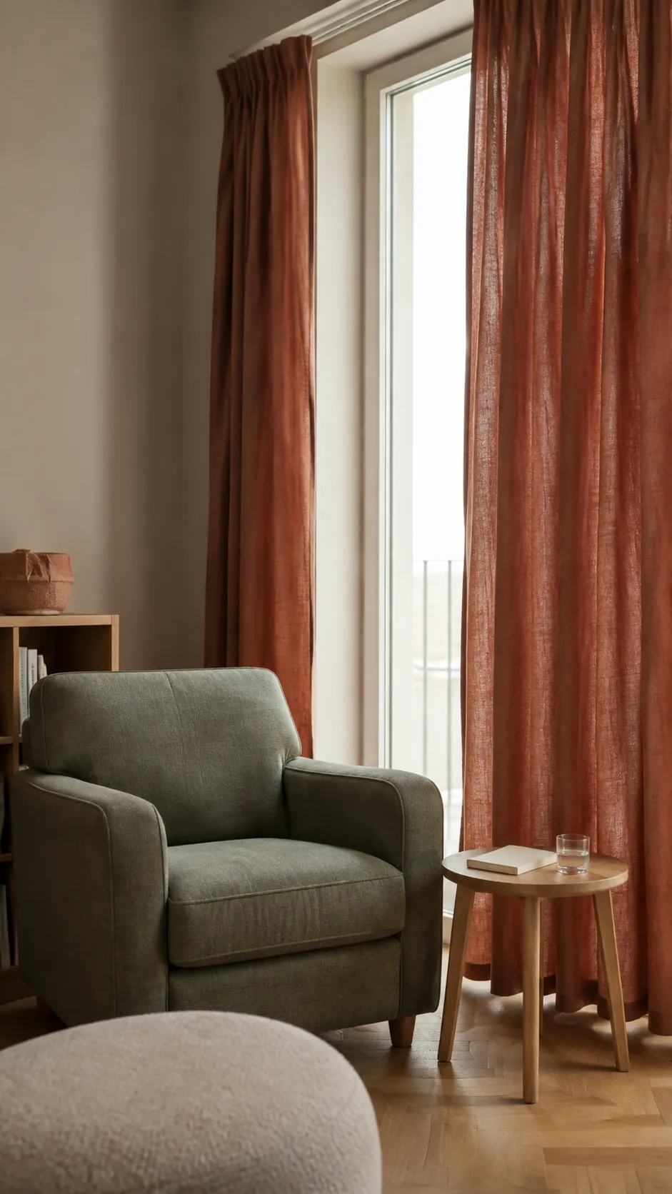 Olive Green and Terracotta nursery with gray olive upholstered chair beside rust linen curtains