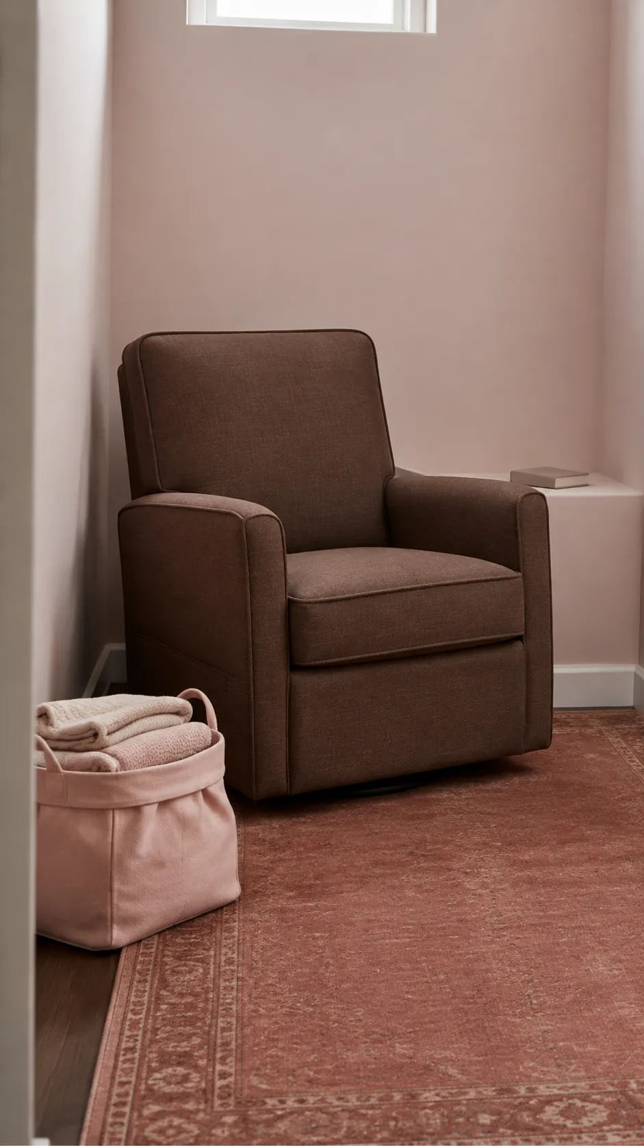 Blush and Cocoa nursery with cocoa brown compact glider with dusty rust rug under blush walls
