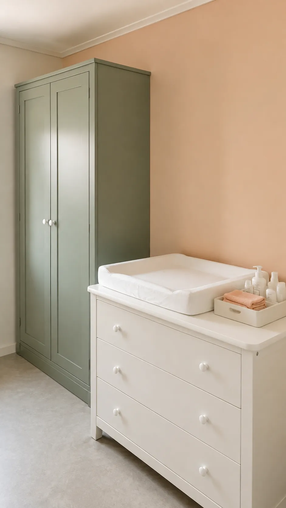 Sage and Apricot Clay nursery with sage wardrobe beside pale apricot wall and white changing surface