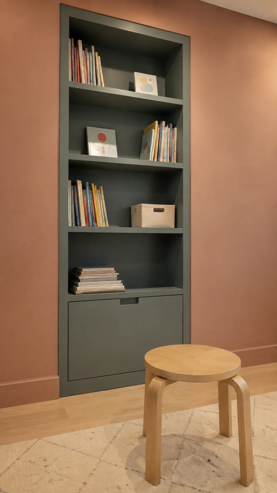 Muted Teal and Peach Terracotta nursery with muted teal built in bookcase surrounded by peach clay paint