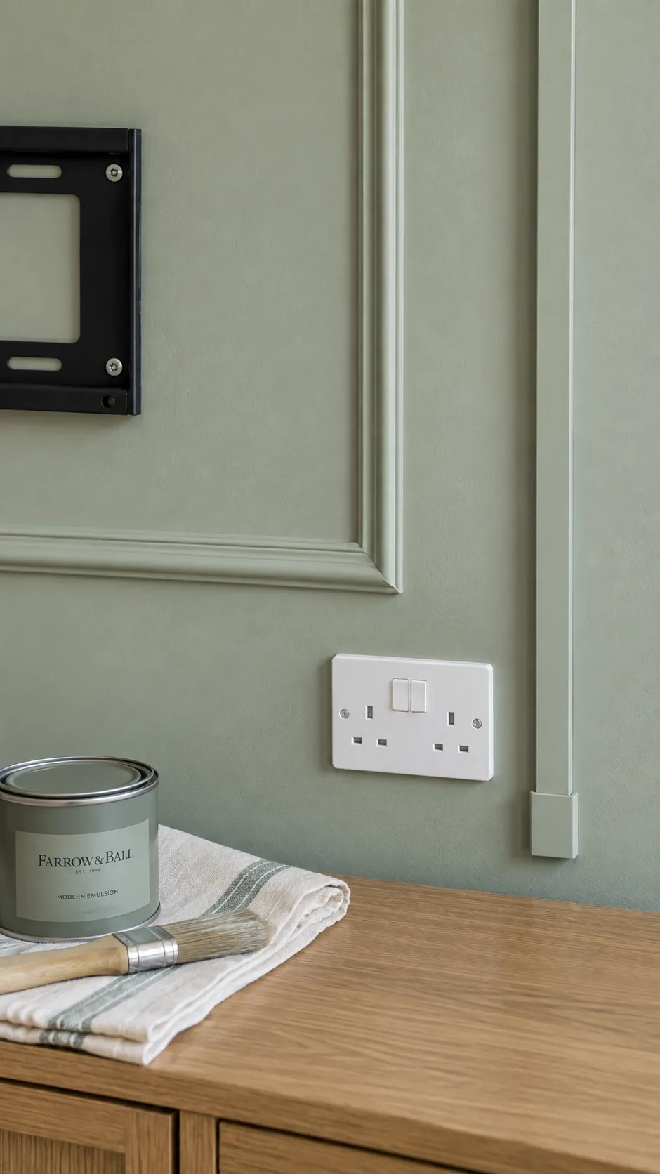 Create a detail photograph of neatly finished decorative molding beside a television service area