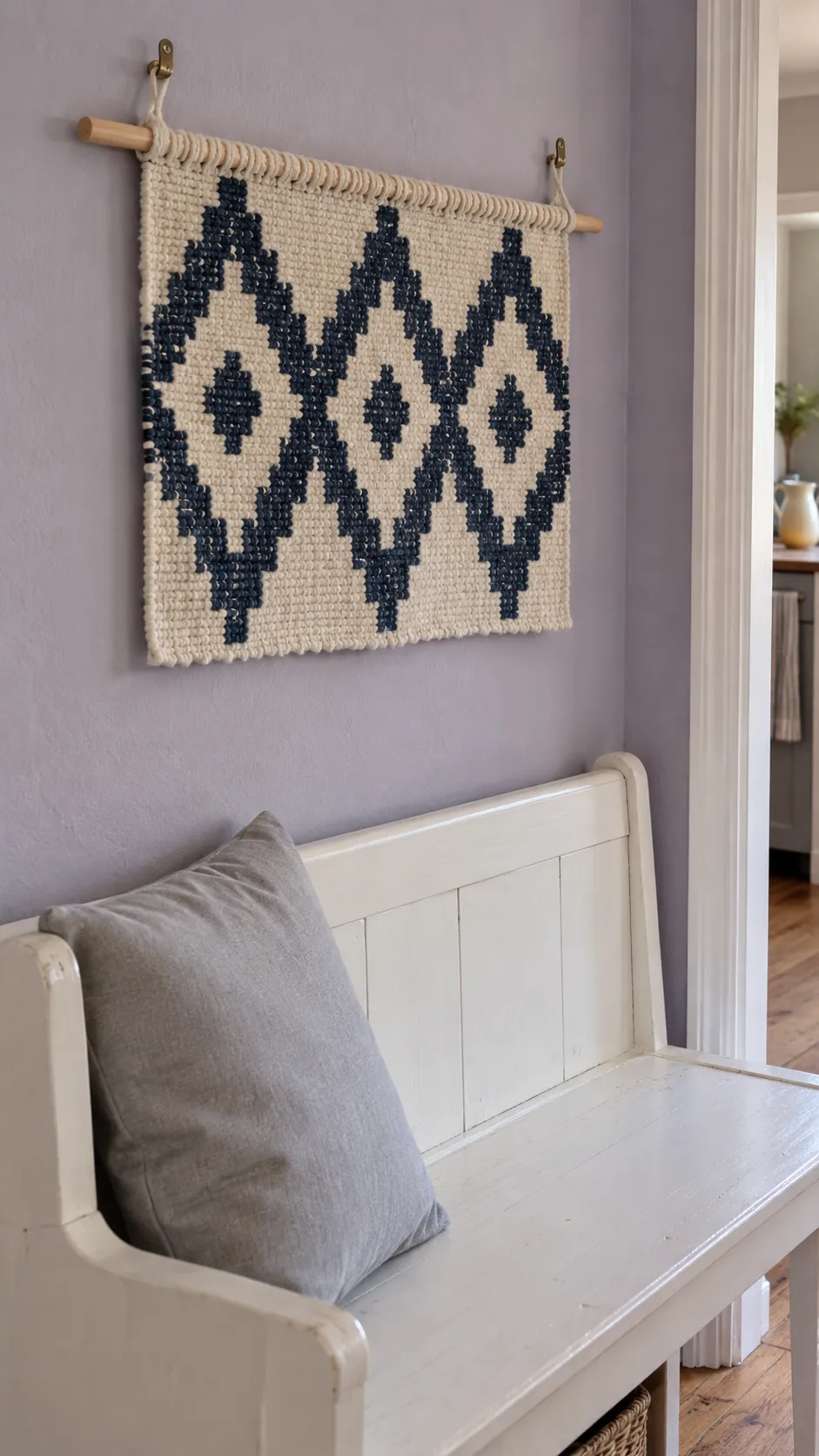 Show a lightweight woven wall hanging as a low projection alternative to a shelf above a frequently used bench