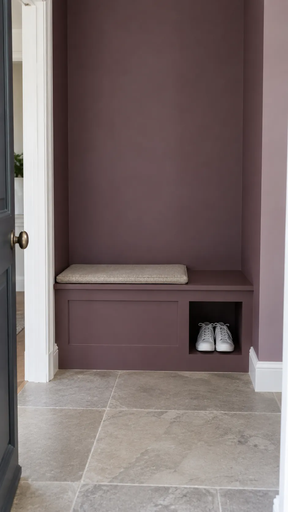 Photograph a small built in bench nook unified by a single paint color so the wall itself supplies the decoration
